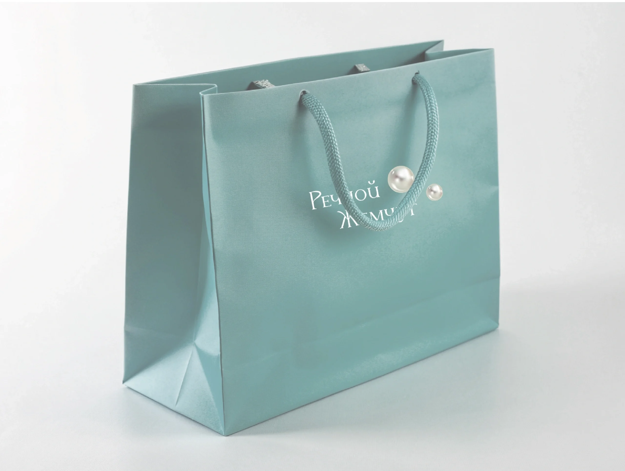 White luxury paper bag with twisted cord handles.