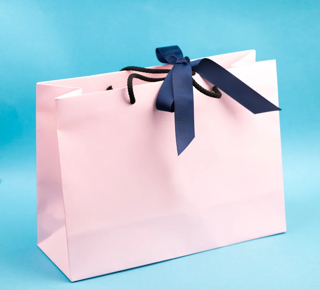 Eco-friendly paper shopping bag with handle and decorative ribbon