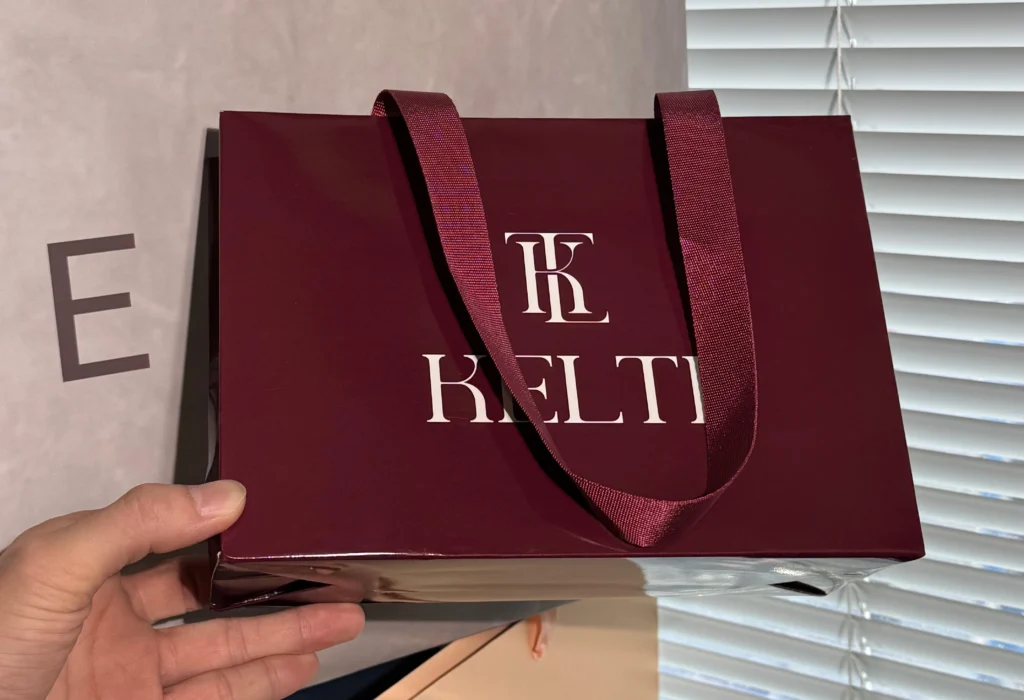 Red paper bag with glossy lamination, ideal for gift packaging or retail use.